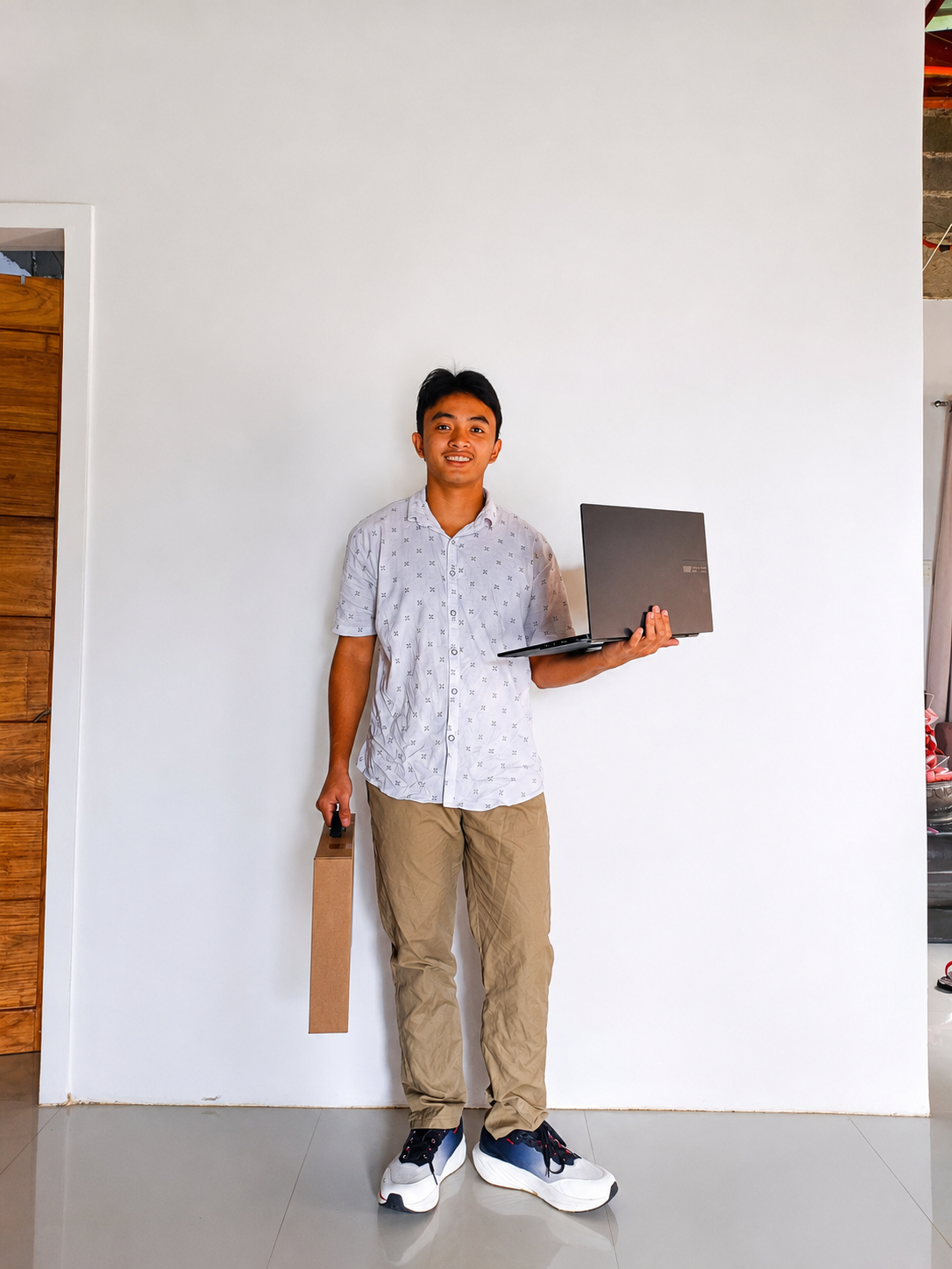 Jerald Acero standing with a laptop in one hand